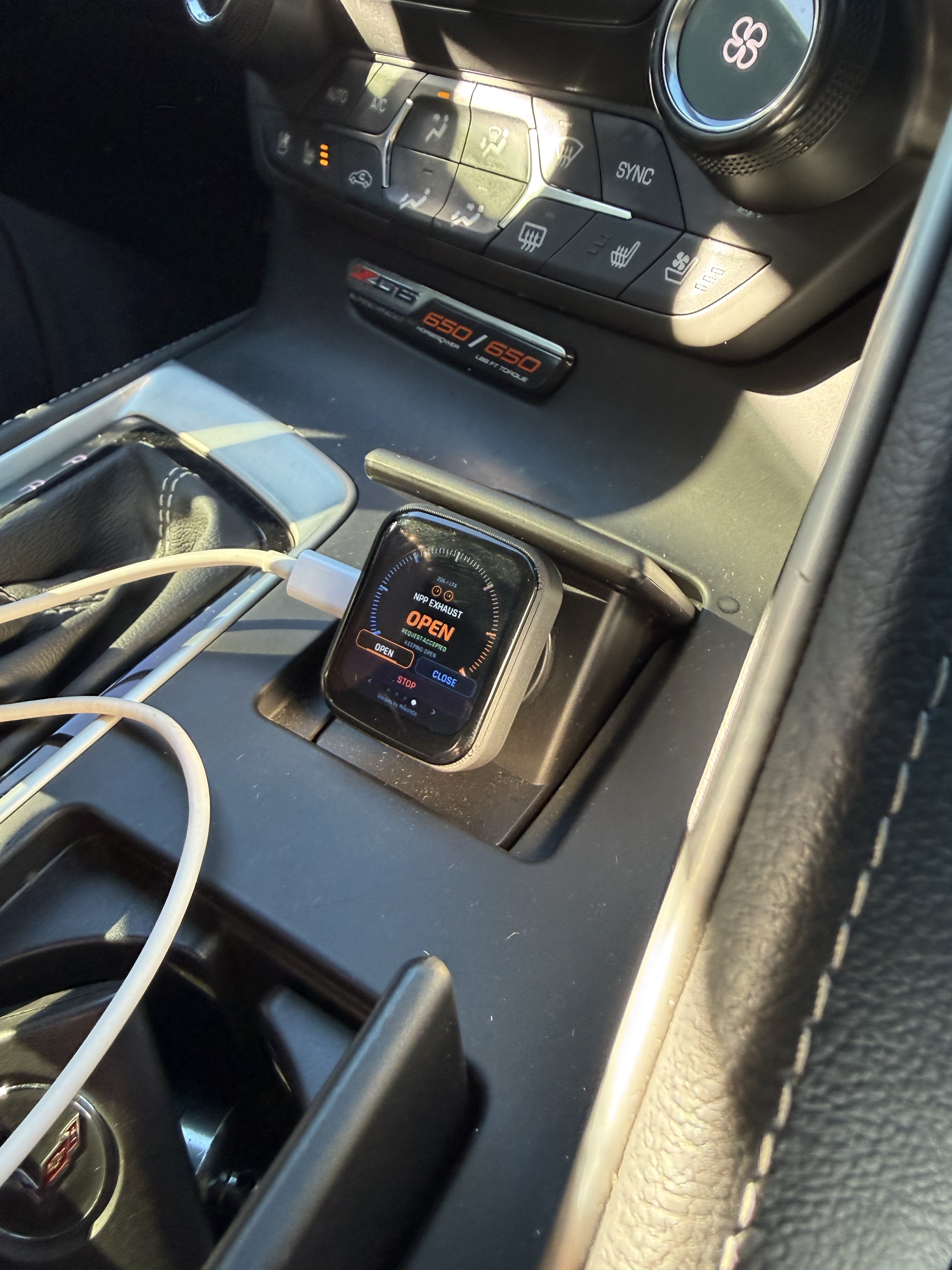 Actual Corvette C7 Z06 installation with the compact gauge and NPP exhaust screen mounted in the center-console cigarette-lighter compartment
